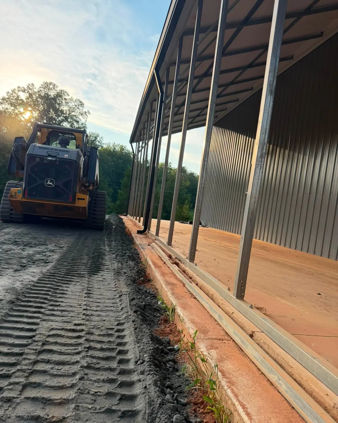 Dozer grading the ground beside a metal-roof building