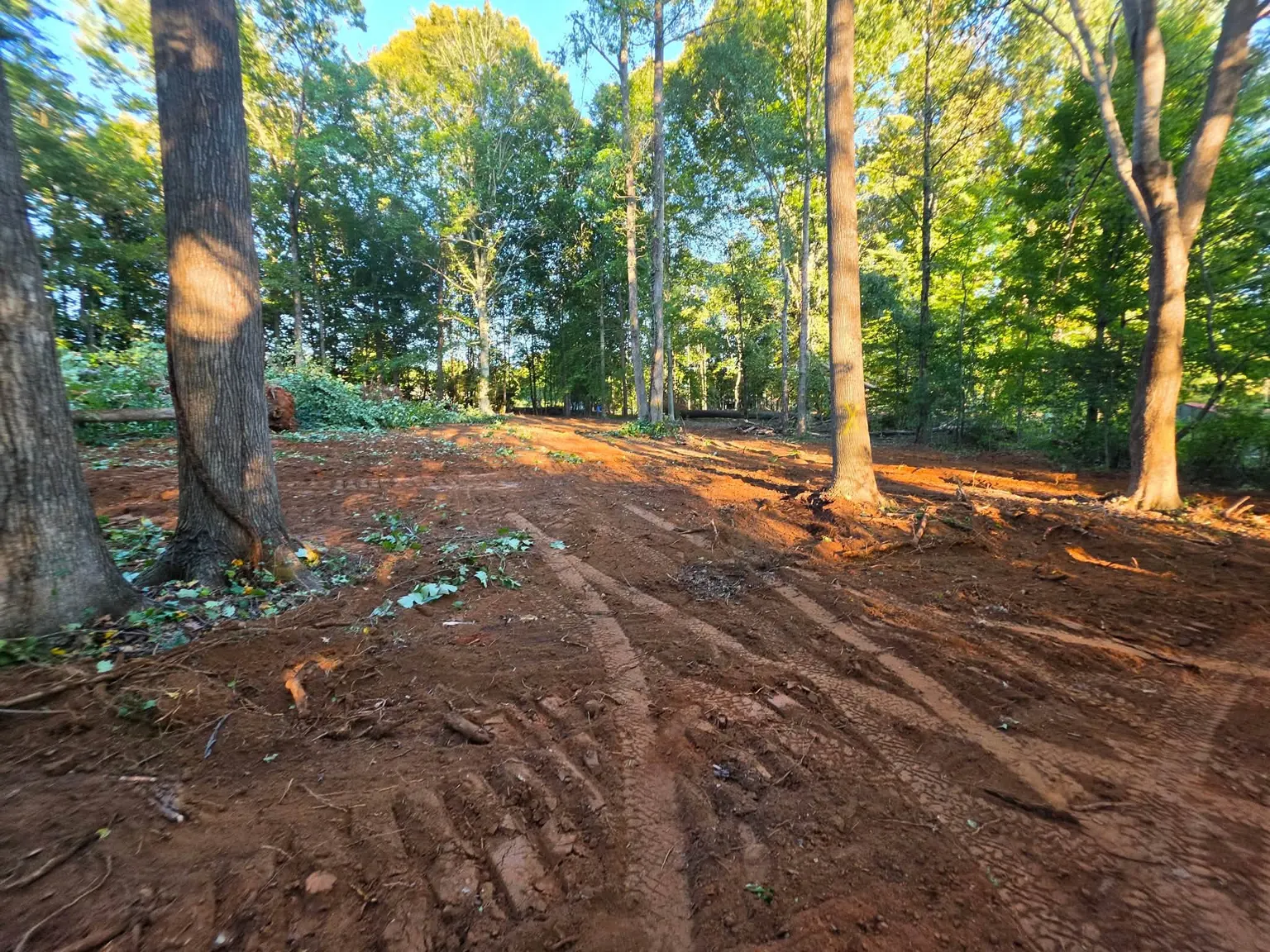 Grading crew starting a house site, cleared pad with dozer tracks