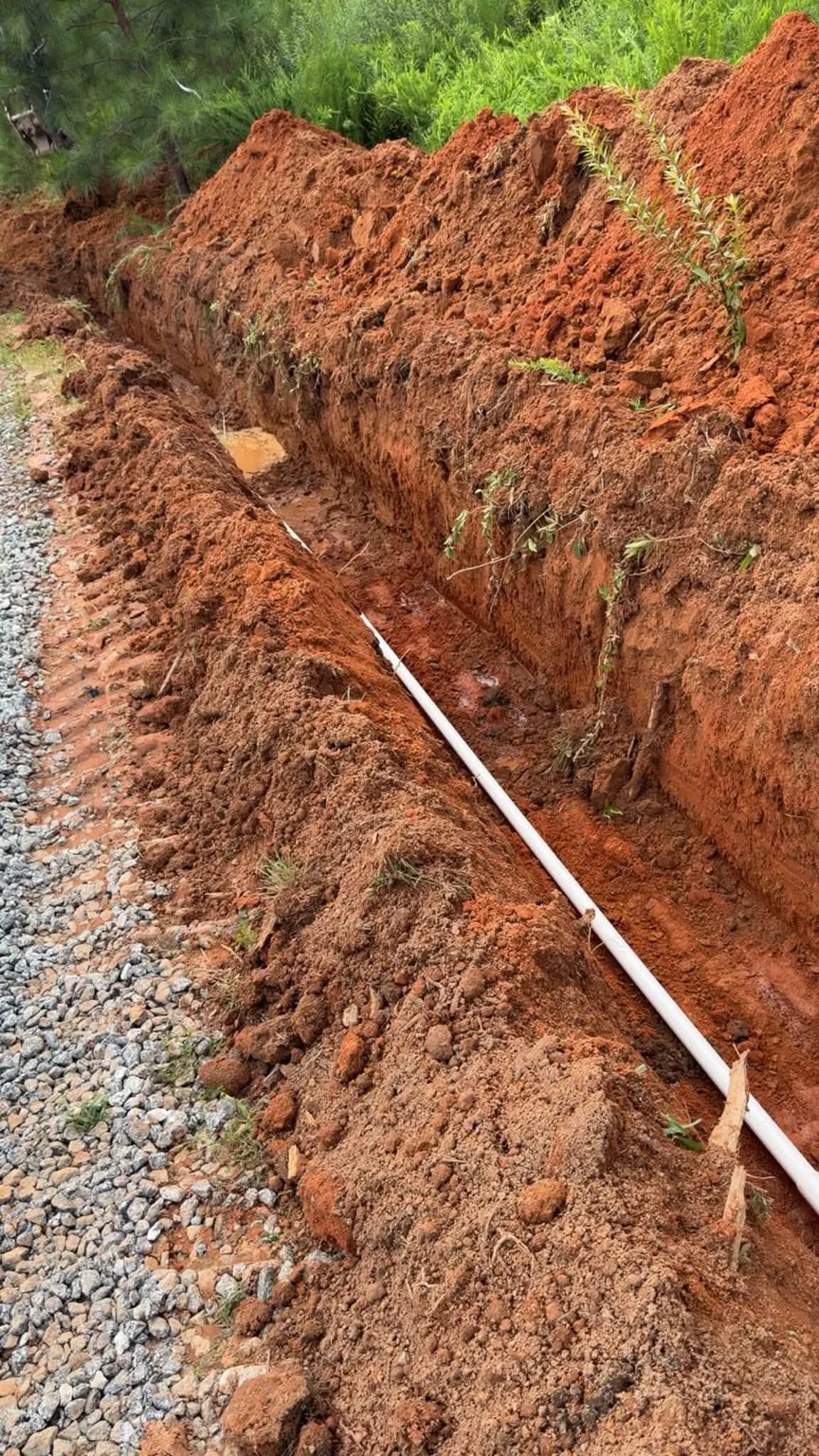 Water pipe running along the bottom of a red-clay trench
