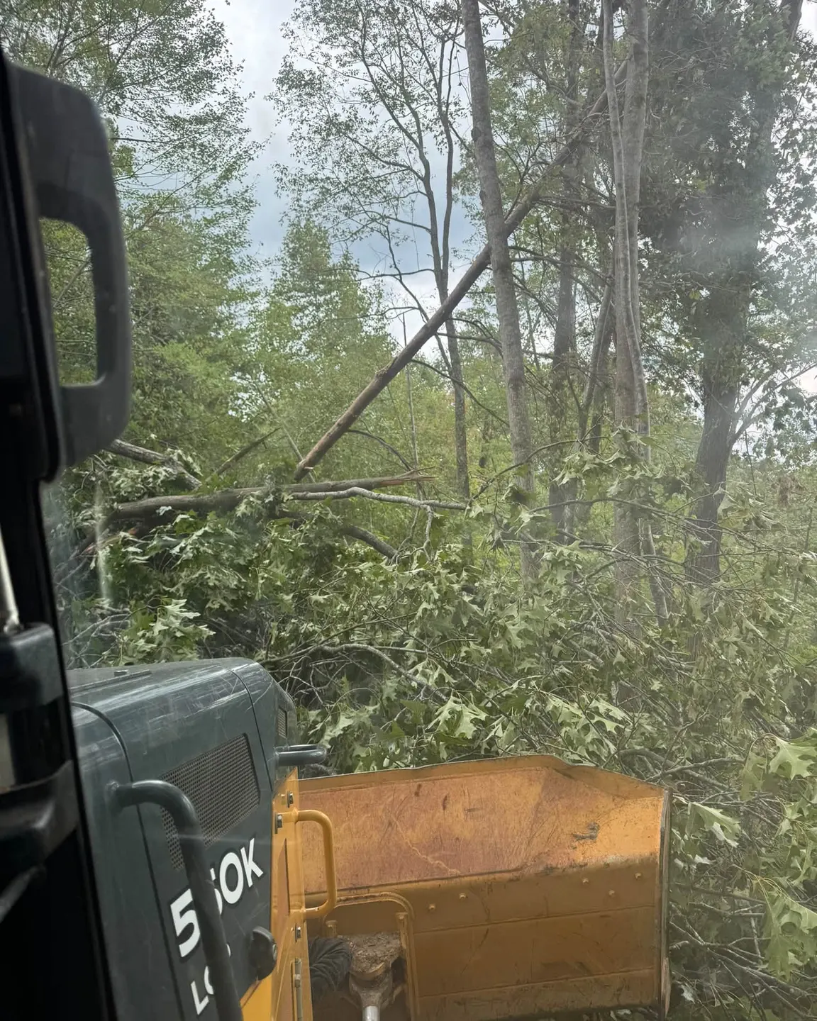 Clearing downed trees with a grapple after a storm